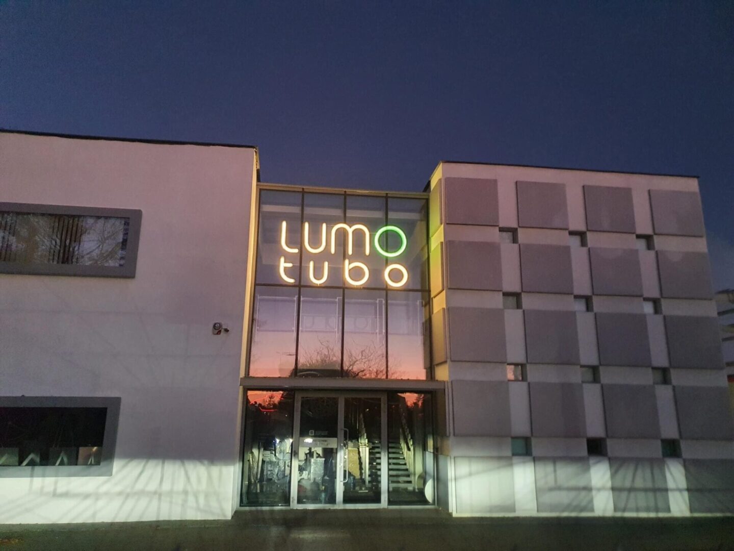 Instalacja liter świetlnych w stylu neon- logo Lumotubo na fasadzie budynku siedziby głównej.